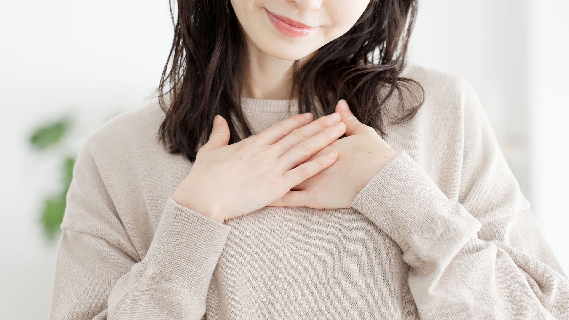 A woman who feels happy with her hands on her chest